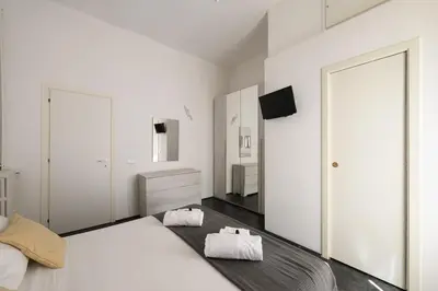 a white bedroom with a large bed and a television at Lovely apartment in the City Centre in Rome