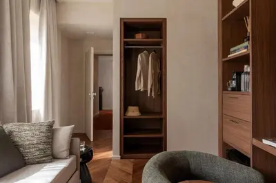 a living room with a chair and a closet at NAMAN HOTELLERIE - Condotti in Rome
