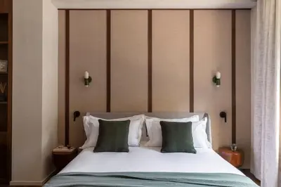 a bedroom with a large bed with green and white pillows at NAMAN HOTELLERIE - Condotti in Rome