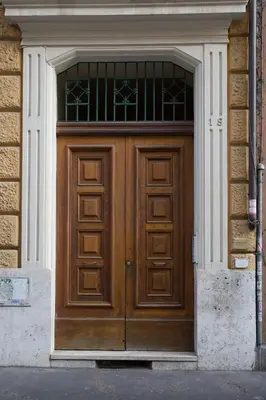 a large wooden door in a brick building at Roma San Peter Suite in Rome