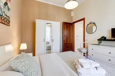 a bedroom with a white bed and a dresser at Karolina's Home, 2-BDR at Vatican in Rome