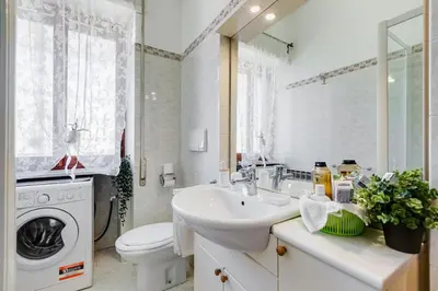 a bathroom with a sink and a washing machine at Karolina's Home, 2-BDR at Vatican in Rome