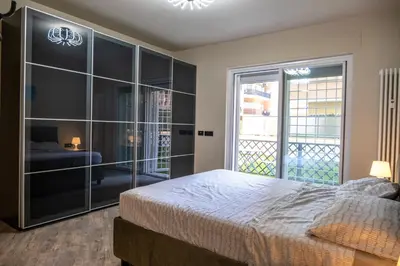 a bedroom with a large bed and a balcony at zampieri house camera blu in Rome