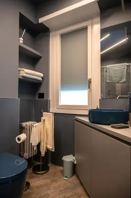 a bathroom with a blue sink and a window at zampieri house camera blu in Rome