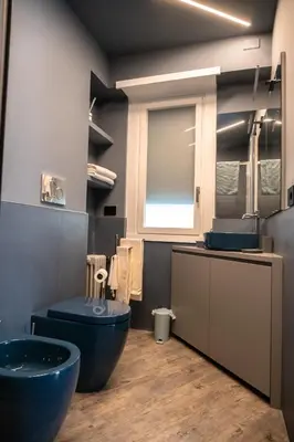 a bathroom with two sinks and a blue toilet at zampieri house camera blu in Rome
