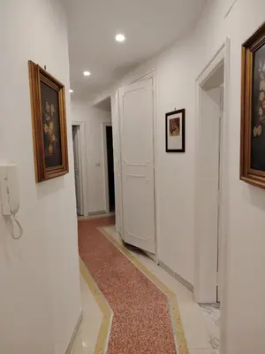 a hallway with a white door and paintings on the walls at Anna Roma House 2 in Rome