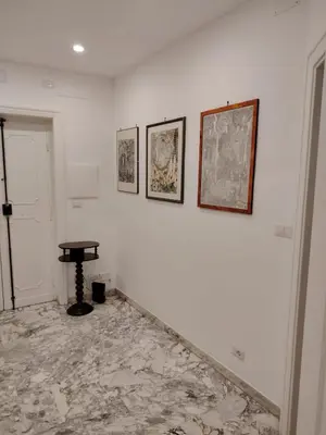 a white room with a table and pictures on the wall at Anna Roma House 2 in Rome