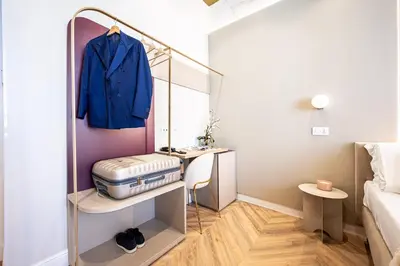 a small room with a dressing table and a blue jacket at Bea Boutique Hotel in Rome