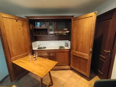 a kitchen with wooden cabinets and a wooden table at Charming Trastevere Sun in Rome