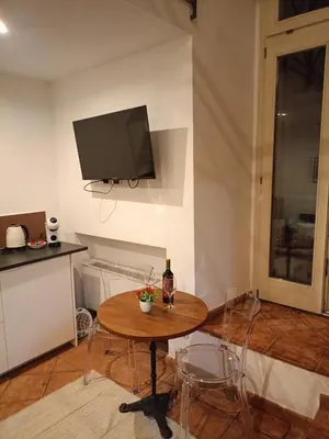 a living room with a table and a tv on the wall at Charming Trastevere Sun in Rome