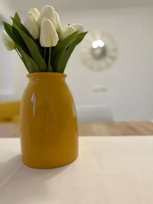 a yellow vase with white flowers in it on a table at Rome s finest in Rome