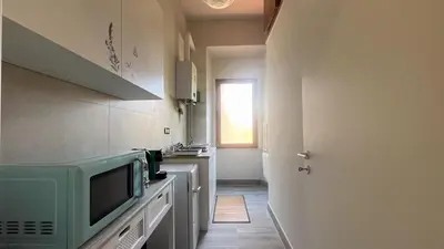 a small kitchen with a microwave and a window at La casa dell'artista in Rome