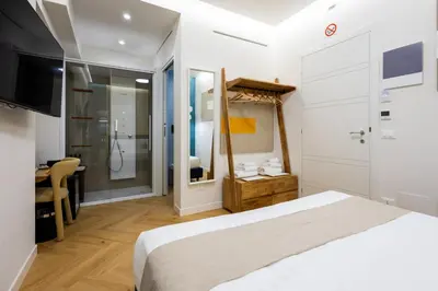 a bedroom with a white bed and a desk at Barberini Design Suites in Rome