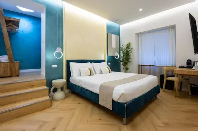 a bedroom with a bed with a blue wall at Barberini Design Suites in Rome