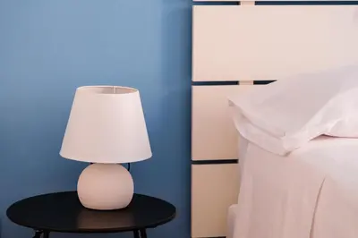 a lamp sitting on a table next to a bed at VG Apartment - Re di Roma in Rome