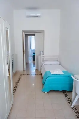 a bedroom with a bed in a white room at VG Apartment - Re di Roma in Rome