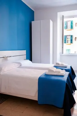 a bedroom with a large bed with blue walls at VG Apartment - Re di Roma in Rome