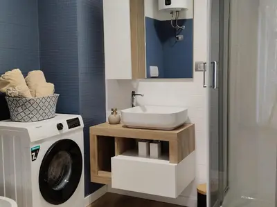 a bathroom with a washing machine and a sink at Metro Re di Roma Apartment in Rome