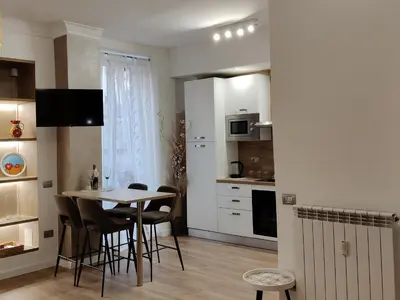 a kitchen and dining room with a table and chairs at Metro Re di Roma Apartment in Rome