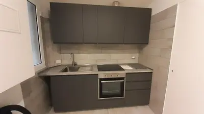 a kitchen with black cabinets and a sink at Vatican Rooms Cipro 2 in Rome