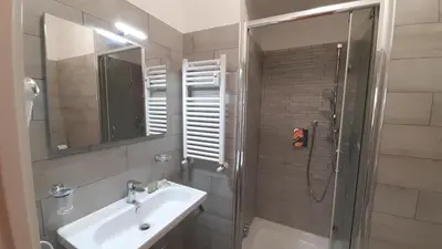 a bathroom with a sink and a shower with a mirror at Vatican Rooms Cipro 2 in Rome