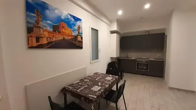 a dining room with a table and a kitchen at Vatican Rooms Cipro 2 in Rome