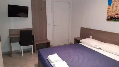 a bedroom with a bed and a desk and a chair at Vatican Rooms Cipro 2 in Rome