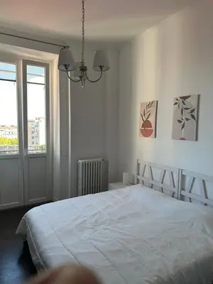 a white bedroom with a bed and a window at La Casa di Bru - Cinque Camere - Dieci posti - Terrazzo in Rome