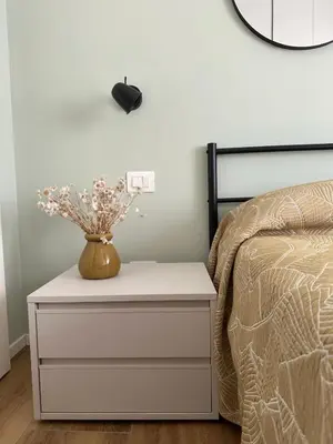 a nightstand with a vase on it next to a bed at Rhome Holiday Home Casal Bertone in Rome