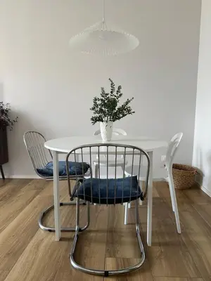 a white table with chairs and a vase with a plant at Rhome Holiday Home Casal Bertone in Rome