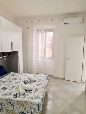 a bedroom with a bed with white sheets and a window at Rome Central Colosseum Flat in Rome