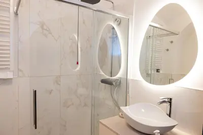 a bathroom with a shower with a sink and a mirror at Dimora Conti in Rome