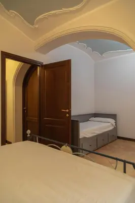 a room with a bed and a wooden door at Dimora Conti in Rome