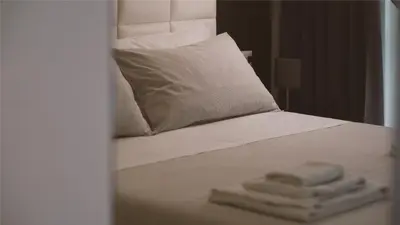 a bed with a pillow and two towels on it at Morin 10 Rome Exclusive Suites in Rome