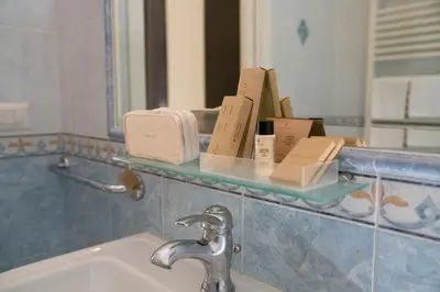 a bathroom with a sink and a shelf with toiletries at Morin 10 Rome Exclusive Suites in Rome