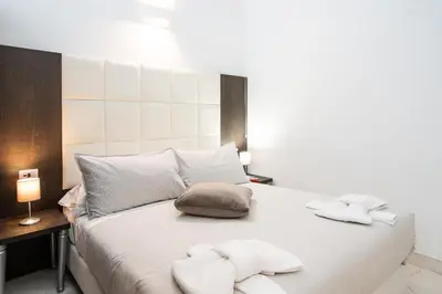 a white bed with two towels on top of it at Morin 10 Rome Exclusive Suites in Rome