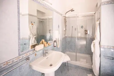 a white bathroom with a sink and a shower at Morin 10 Rome Exclusive Suites in Rome