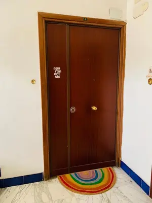 a wooden door with a rainbow rug in front of it at Apartment SIX Rome Flaminio - Villaggio Olimpico in Rome