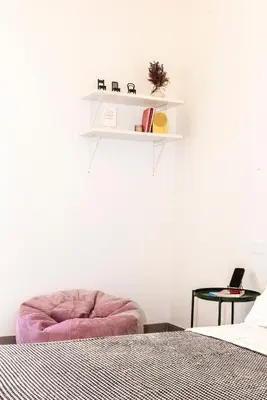 a bedroom with a bed and a shelf on the wall at Casa Chiagio in Rome
