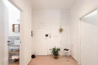a white hallway with a door and a plant at Casa Chiagio in Rome