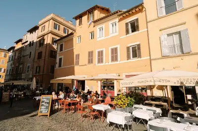 a group of people sitting at tables in front of buildings at Maison Luxury Plaza in Rome