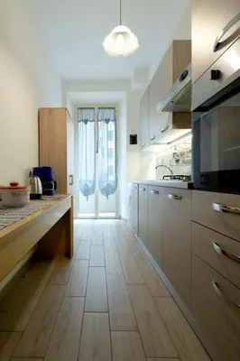 a kitchen with wooden cabinets and a large window at Holiday Season in Rome