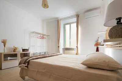 a white bedroom with a large bed and a window at Holiday Season in Rome