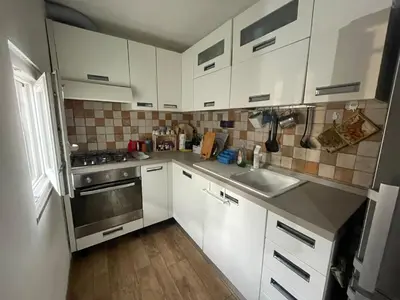 a kitchen with white cabinets and a stainless steel sink at Cozy house with terrace in Rome