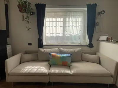 a couch in a living room with a window at Cozy house with terrace in Rome