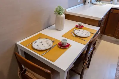 a small kitchen table with two plates and cups on it at Apartment Casa Girina Boutique in Rome