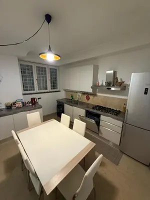 a kitchen with a table and chairs and a refrigerator at Family Entire House in Rome