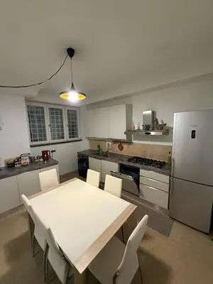 a kitchen with a table and chairs and a refrigerator at Family Entire House in Rome