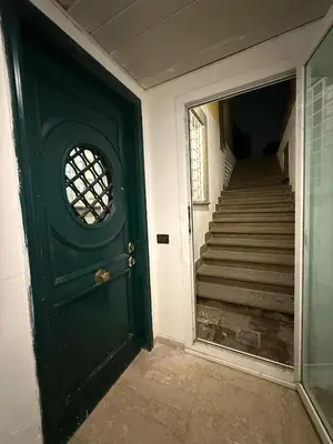 a green door in a hallway with a staircase at Family Entire House in Rome