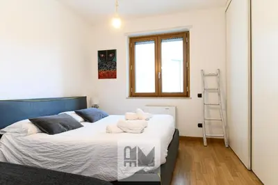 a bedroom with a bed with white sheets and a window at Nuovo appartamento stazione Tiburtina in Rome